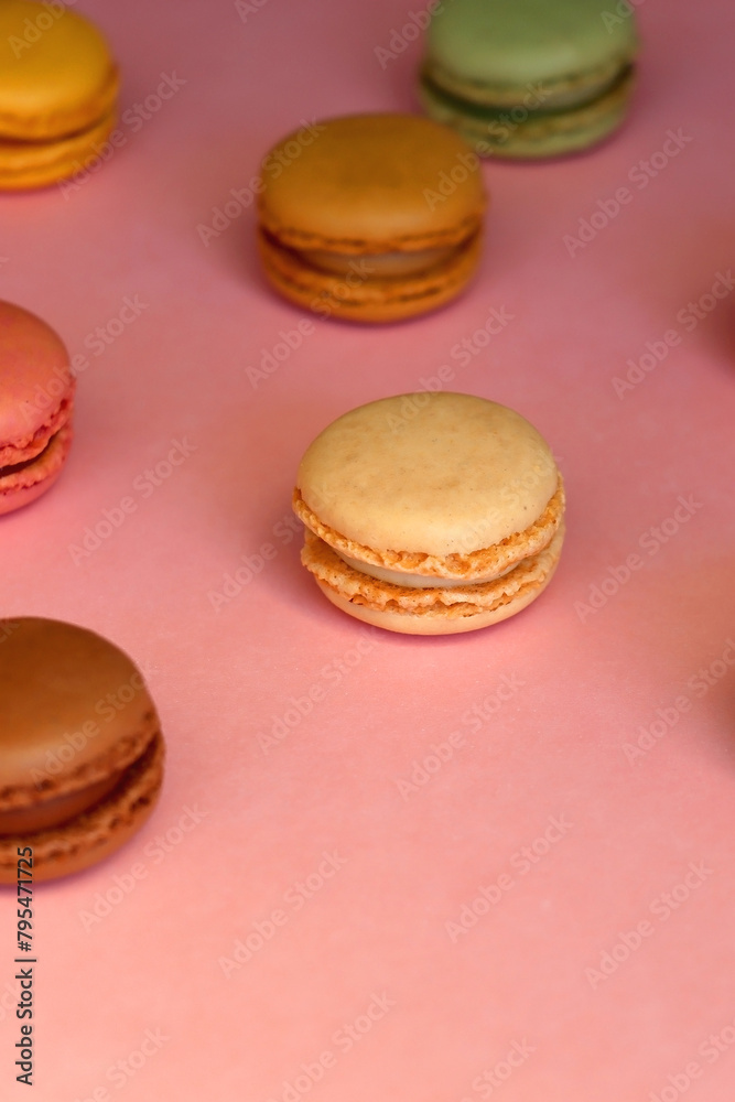 Fototapeta premium Colorful macarons on pink background. Selective focus.