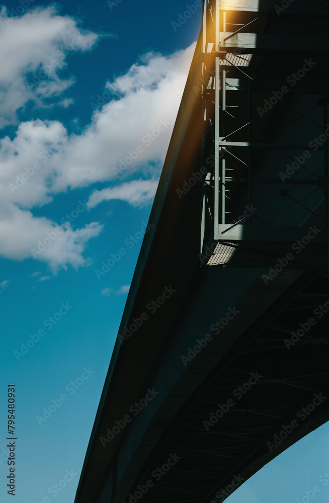 view from the bottom of the bridge against the blue sky view from the bottom of the bridge against the blue sky