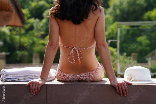 Rear view of a female body in a luxury jacuzzi of a resort. Relaxation in summer holidays