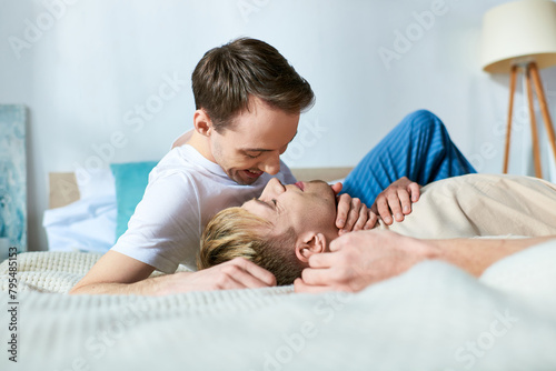 Two men relax on a bed in a cozy setting. photo