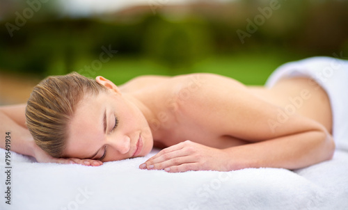 Spa, relax and massage with woman on bed for healing, treatment or pamper in peace at luxury hotel. Female person, client and sleeping with body care at resort for wellness, peace or rest on vacation