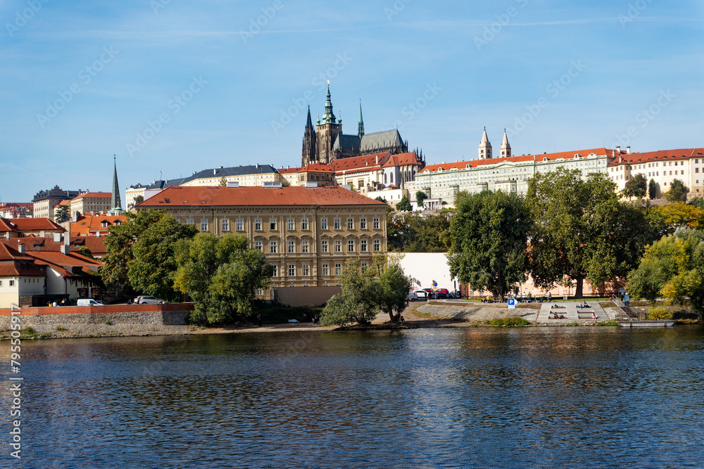 Scenic view of Moldova River with skyline of City of Prague with St. Vitus Cathedral and castle the background on a sunny autumn day. Photo taken October 11th, 2023, Prague, Czech Republic.