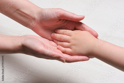 World mother day concept background. Mother and son hands close up. photo