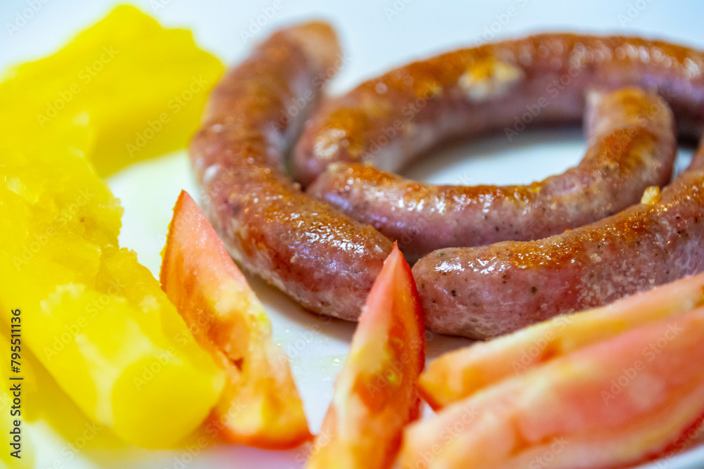 Fototapeta premium Traditional rustic Brazilian food, sausage with cassava and tomatoes