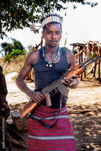 Ethiopia, young man  from the Bana tribe with  his weapon in the  village of Shaba. 20th of february 2024