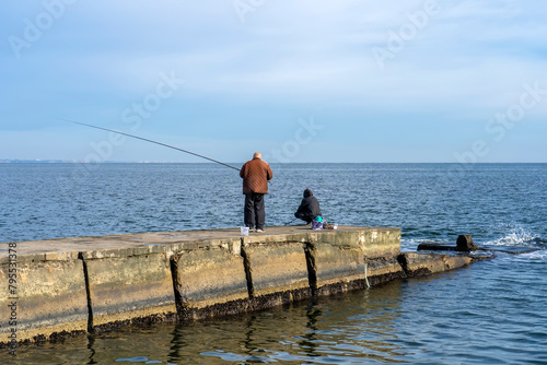 Fishermen on the pier catch fish