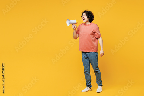 Full body young shocked man he wears pink t-shirt casual clothes hold in hand megaphone scream announces discounts sale Hurry up isolated on plain yellow orange background studio. Lifestyle concept. photo