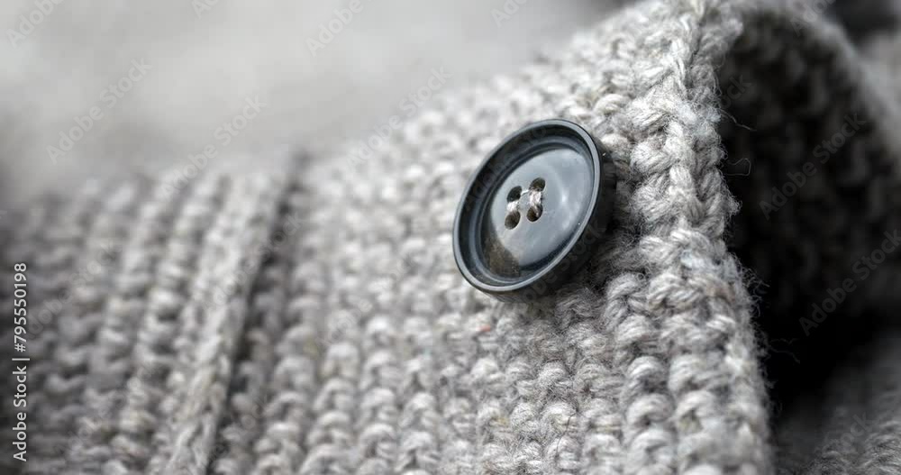 extreme close-up of a button on a knitted cardigan extreme close-up of a button on a knitted cardigan