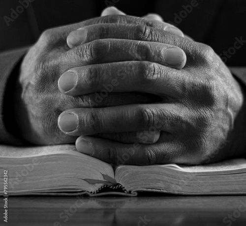 praying to god with hands together on dark background stock photo