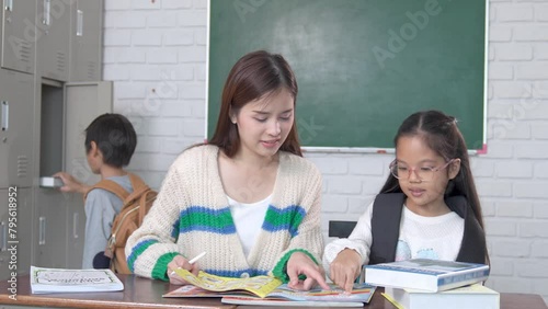 Schoolgirl researching with the guidance of teacher in classroom Education knowledge, successful teamwork concept.