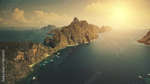 Sunset at tropical island El Nido at blue ocean bay. Sun shine aerial view. Nobody wild nature scenery at amazing tropic mountains islet of Palawan, Philippines archipelago. Cinematic summer vacation photo