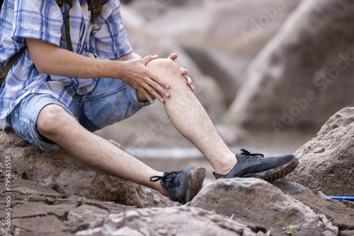 Male trekker grab his knee suffer from knee injured while trekking