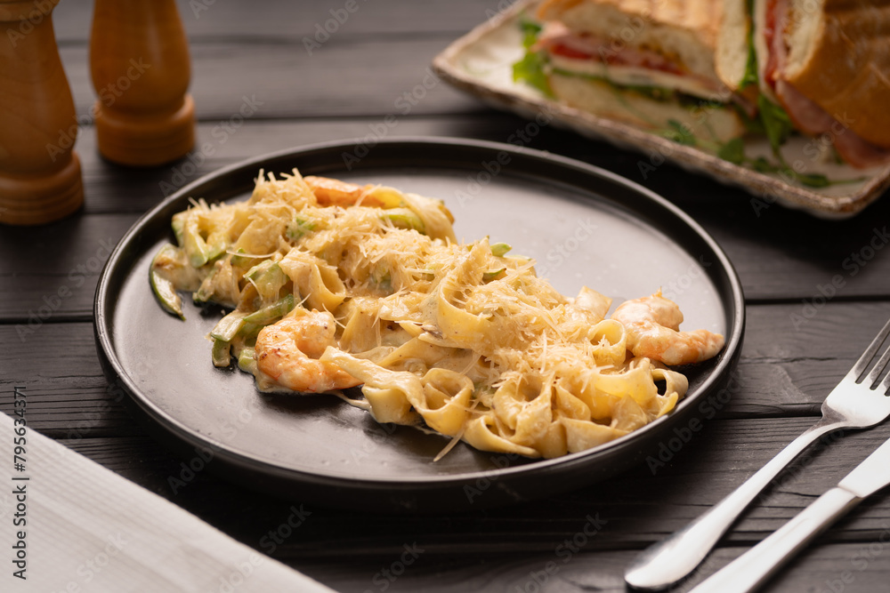 Pasta with Shrimp and Cream Sauce on black plate, Mediterranean Food. Italian Cuisine concept