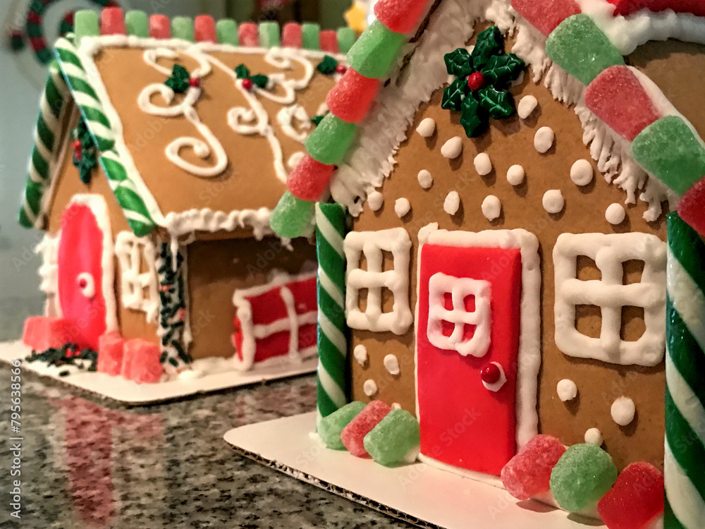 Two homemade, decorated gingerbread houses in Christmas colors