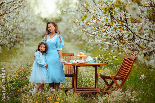 Picnic in a blooming garden. mother and daughter had a spring tea party in the garden