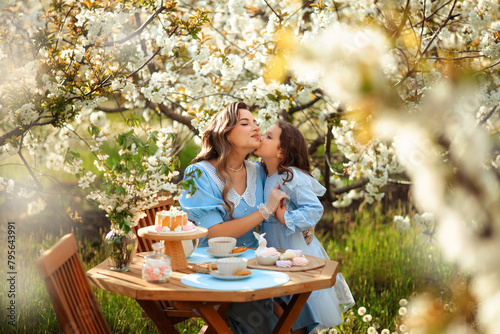 Picnic in a blooming garden. mother and daughter had a spring tea party in the garden