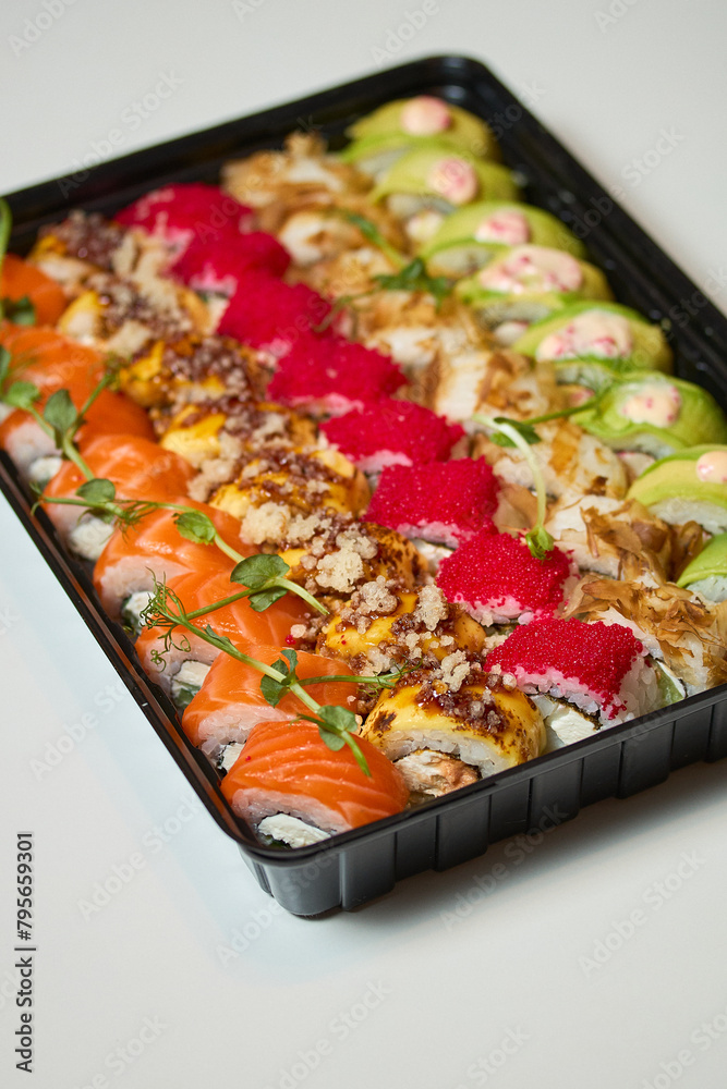 Sushi roll Philadelphia with salmon, smoked eel, avocado, cream cheese on black background. Sushi menu. Japanese food. Sushi roll Philadelphia with salmon, smoked eel, avocado, cream cheese on black background. Sushi menu. Japanese food.