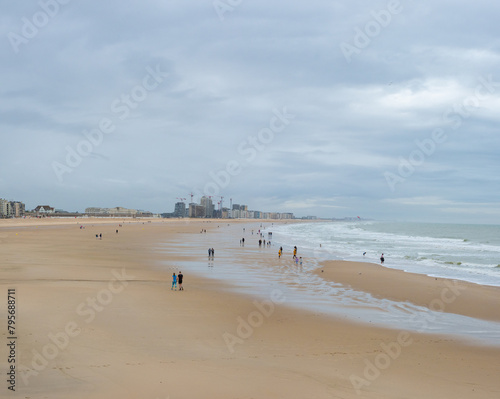 Oostende, Belgium - July 31st: Few people on the wide beach during evening hours in nasty weather