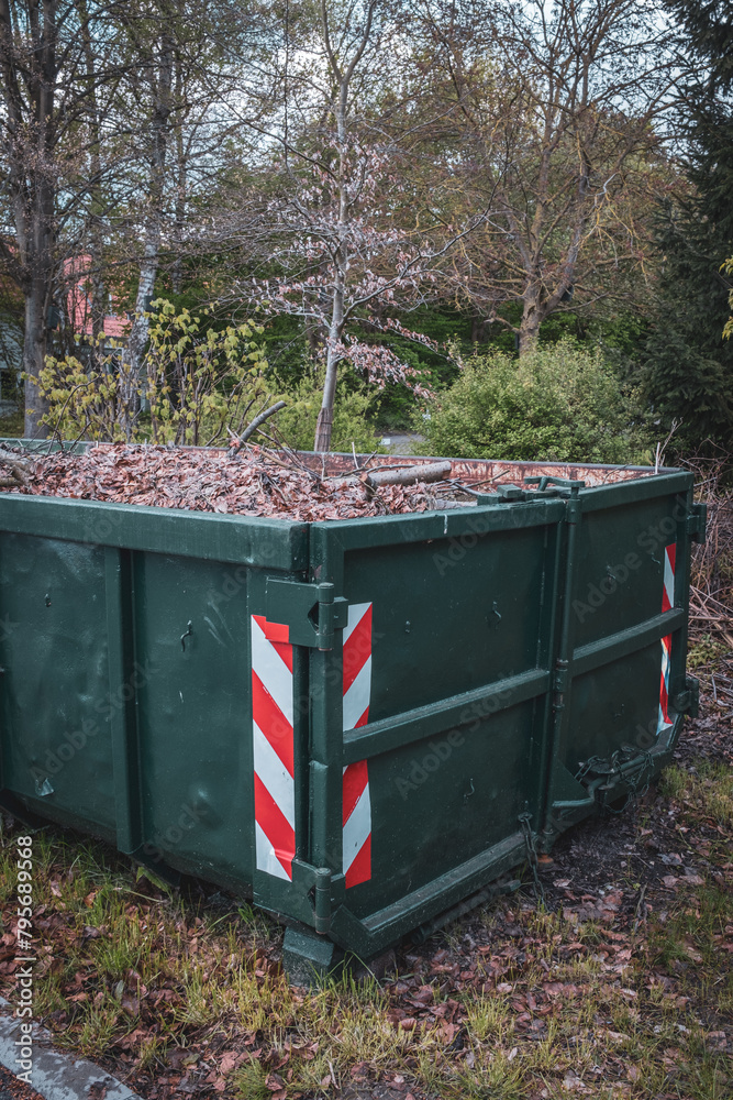 a large green container is completely filled with leaves. a large green container is completely filled with leaves.