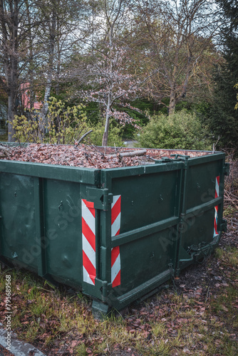 a large green container is completely filled with leaves.