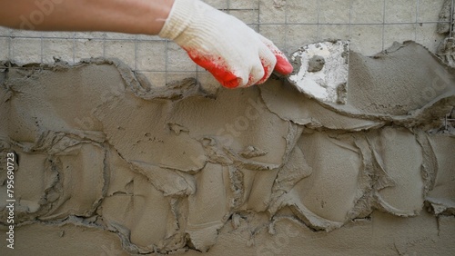 The plaster is applied to the surface with a steel spatula. Decorative plaster based on gray cement, resistant to external influences. The putty is applied to the outside of the building.