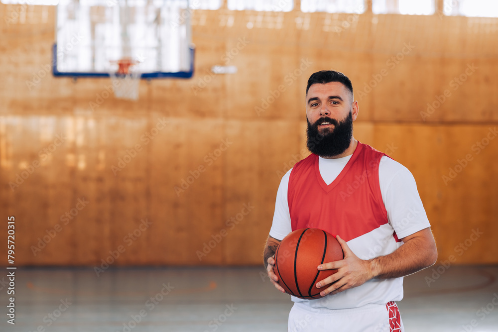 Portrait of a bearded caucasian male basketball player with a ball in his hands