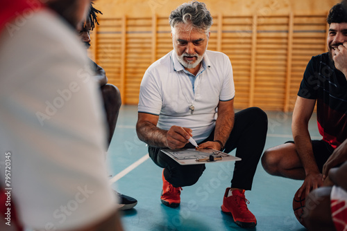 Portrait of a mature basketball coach having a team talk with his diverse team