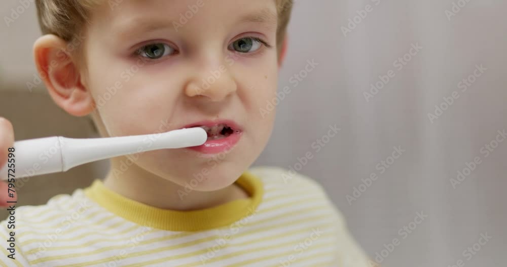 Close-up of a young child using an electric toothbrush, focusing on oral hygiene Close-up of a young child using an electric toothbrush, focusing on oral hygiene