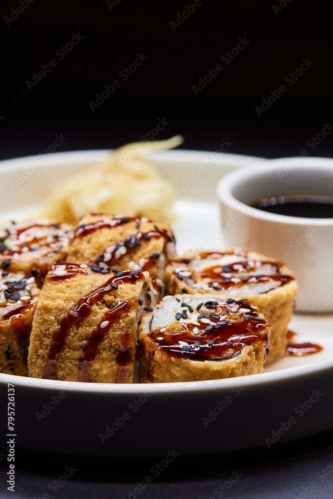 Sushi dish on white plate with sauce, table setting