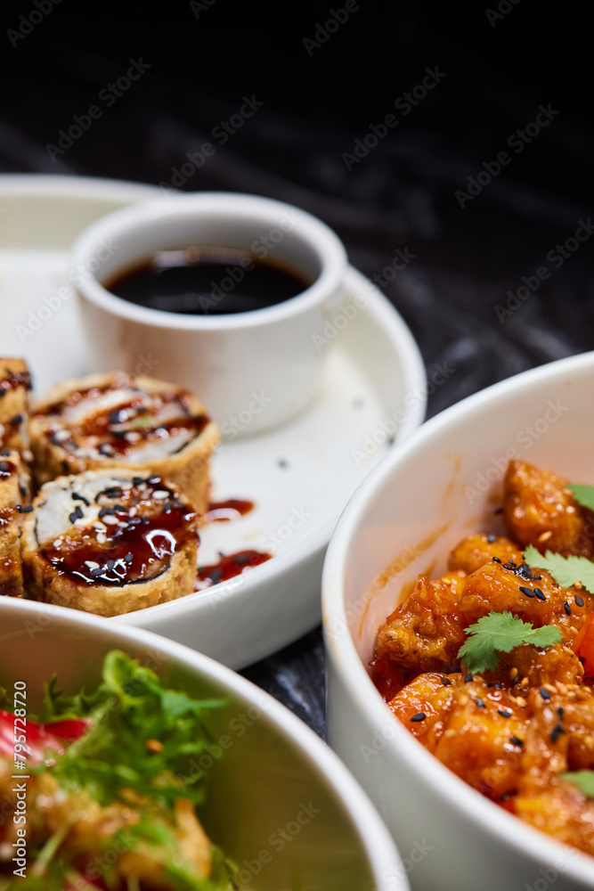 Close up of three bowls with fish ball, leaf vegetable, and plate on table