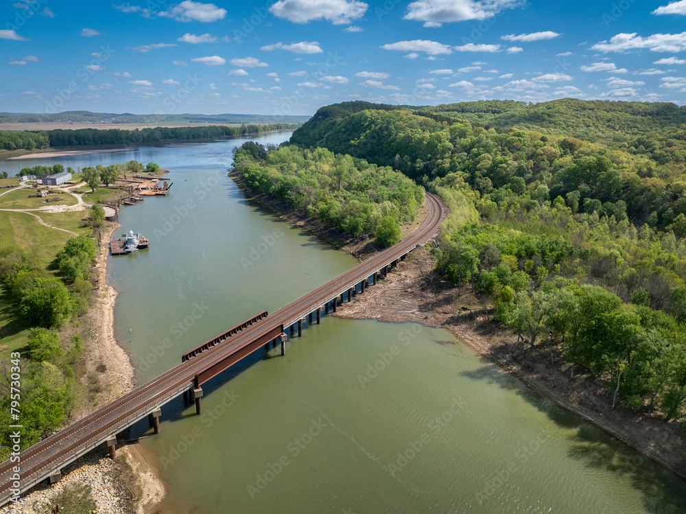 Obraz premium Gasconade River at confluence with the Missouri River, springtime aerial view with a railroad bridge and old boatyard