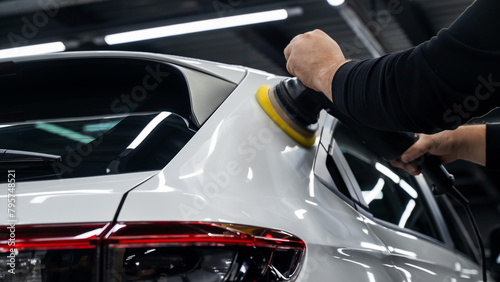 Process of polishing white car body surface using orbital polishing machine.  © Михаил Решетников