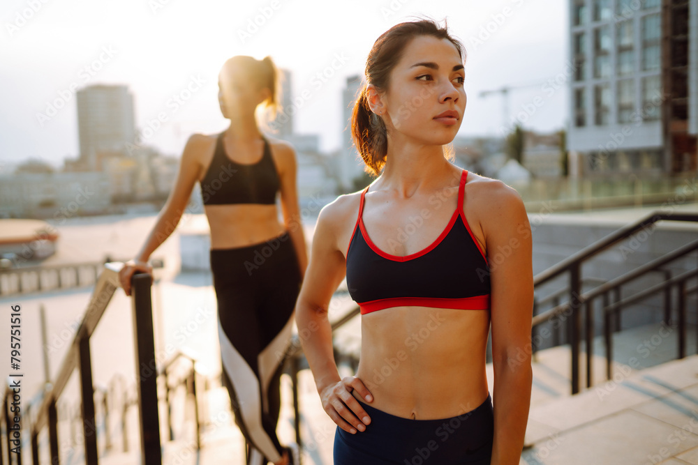 Two women have fitness day outdoors together. Warming up your muscles before an intense workout in the morning. Sport, Active life, sports training, healthy lifestyle. Two women have fitness day outdoors together. Warming up your muscles before an intense workout in the morning. Sport, Active life, sports training, healthy lifestyle.