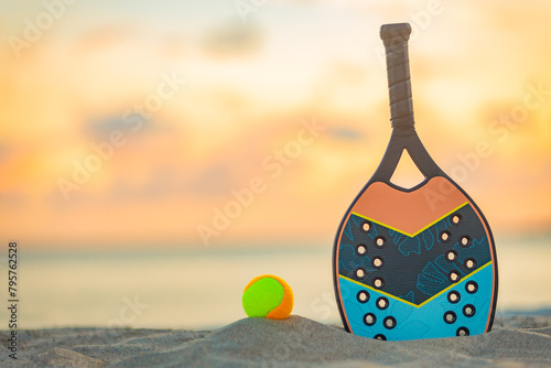 Beach tennis racket. Background with copy space. Sport court at the beach and ball.