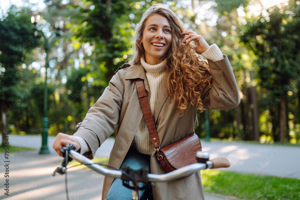 Obraz premium Happy woman tourist woman using bicycle in the park. Active lifestyle. The concept of nature.