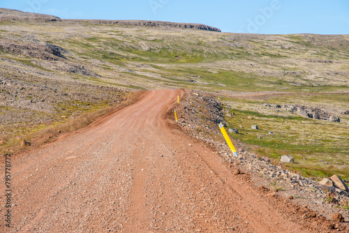 The winding gravel road leading to Raudisandur in the westfjords of Iceland photo