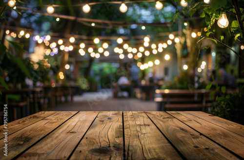 Wooden table perspective with romantic string lights at an outdoor restaurant