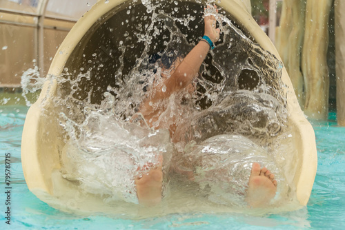 Child enjoying a thrilling slide into water park pool