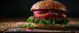 Homemade hamburger featuring a juicy beef patty, fresh lettuce, sliced tomatoes, and tangy pickles. Sandwiched in a toasted bun, it's presented on a rustic wooden background, evoking a classic and