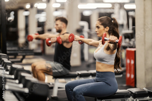 Принти на полотні A fit sporty couple is doing Lateral raise on a blench in a gym.
