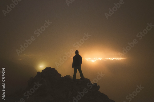 Climber gazing the citylights from the summit of Mt Olympus