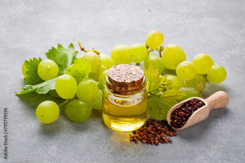 Grape seed oil in small bottle and bunch of grapes together. photo