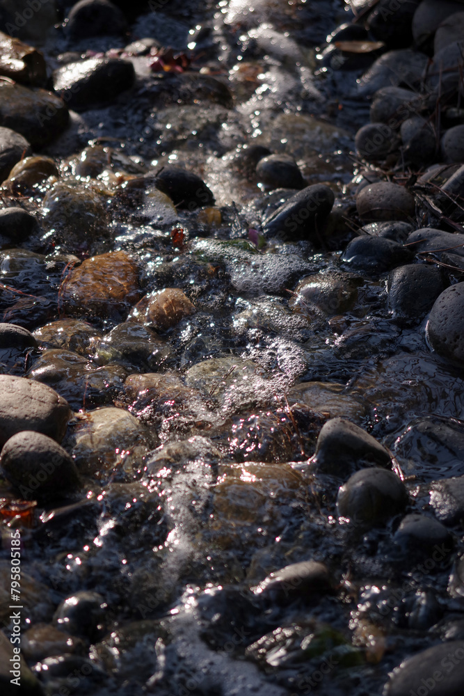Clear creek water flowing over stones and rocks