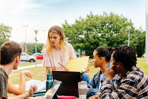 A diverse, multiracial group of college students prepare a class assignment together in the university campus gardens. Diversity and inclusion at school. back to school. © Alberto