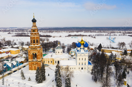 Photography Scenic view from drone of temple complex of Cathedral of Archangel Michael and Church of Jerusalem Icon of Mother of God with Bronnitsy cityscape on background in winter, Russia