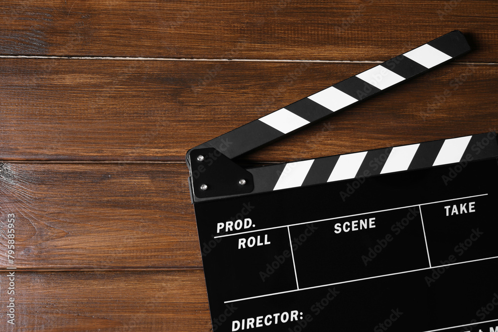 Obraz premium Clapperboard on wooden table, top view. Space for text