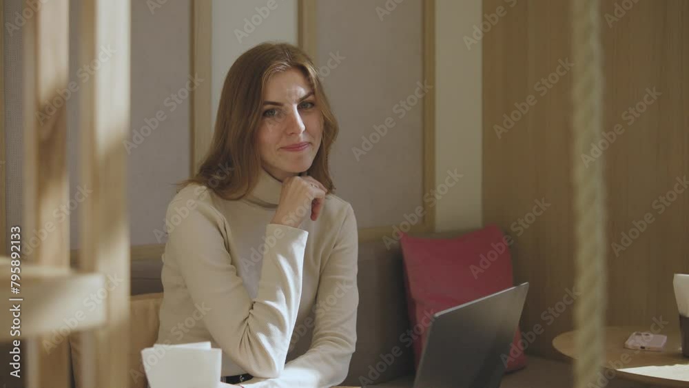Young beautiful red-haired girl working on laptop in a cafe, texting, typing, internet. Portrait. Young beautiful red-haired girl working on laptop in a cafe, texting, typing, internet. Portrait.