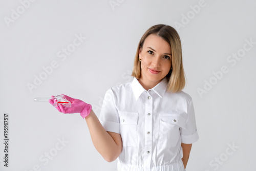 фотографія A beautiful sweet woman gynecologist holds a speculum in hand