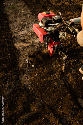 a tillerblock plows the land in the garden. A tillerblock for plowing the land, cultivating the soil in the garden and in the garden.