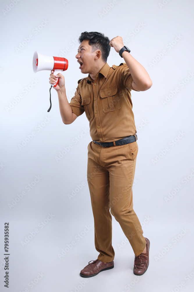 Full Length Portrait of Male Civil Servant in Uniform Announcing Information Using Megaphone on Gray Background Full Length Portrait of Male Civil Servant in Uniform Announcing Information Using Megaphone on Gray Background